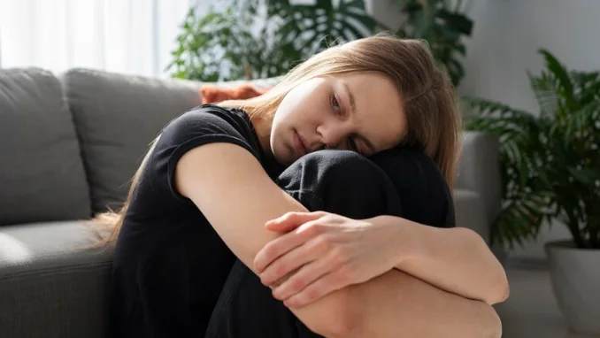 девушка с депрессией сидит на полу